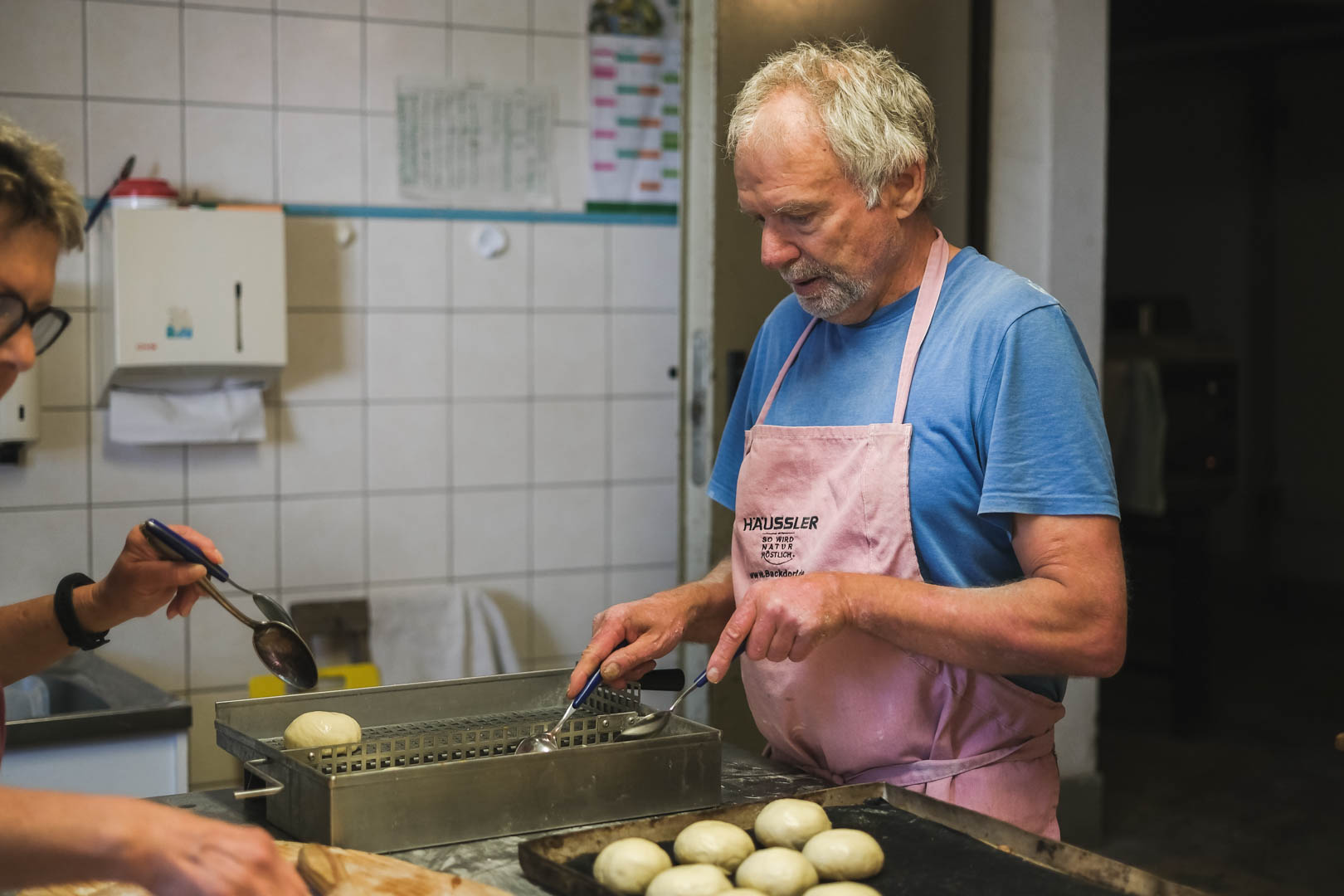Wolfgang Backstube Backhilfe Wolfgang beim Laugenweckle vorbereiten